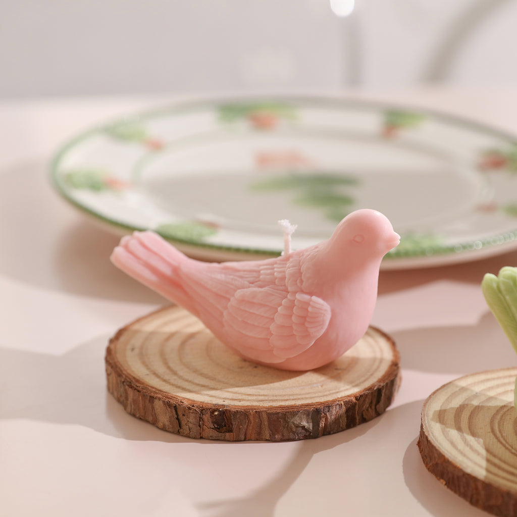 Pink dove-shaped tea light candles on the wooden tray on the dining table, designed by Boowan Nicole.