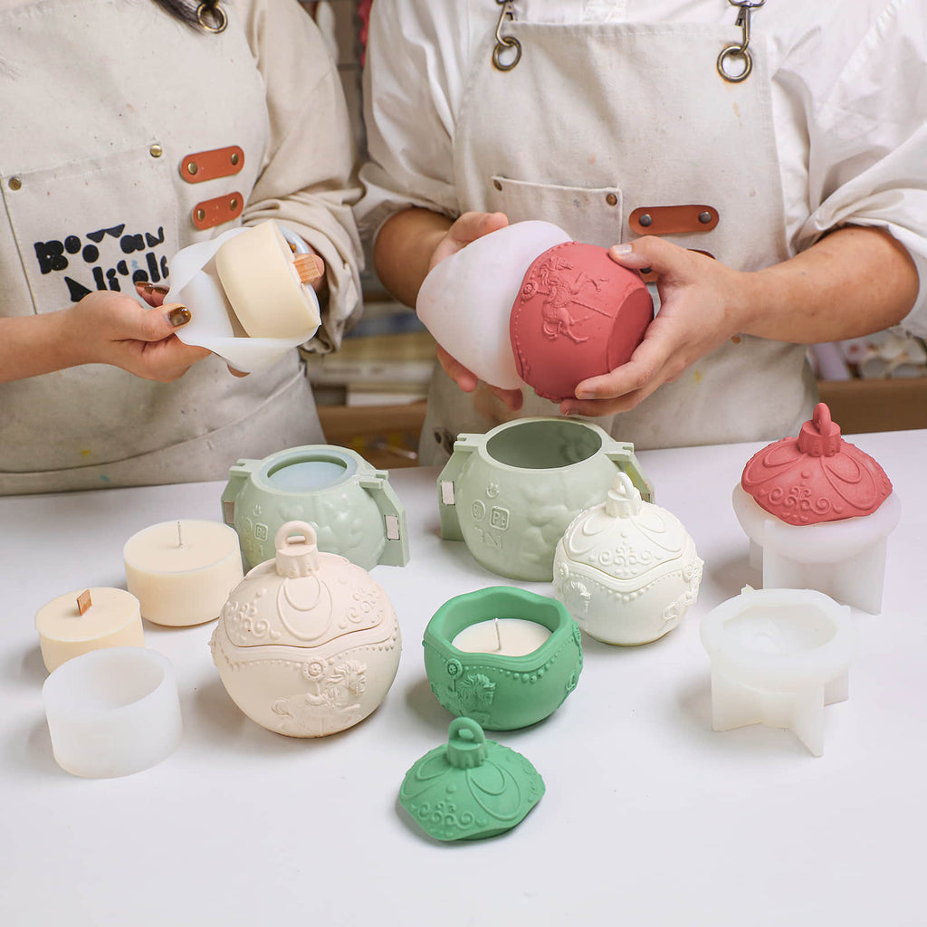 DIY carousel bauble candle jar molds—two crafters demolding and fitting jars with refill candles in the studio - Boowan Nicole