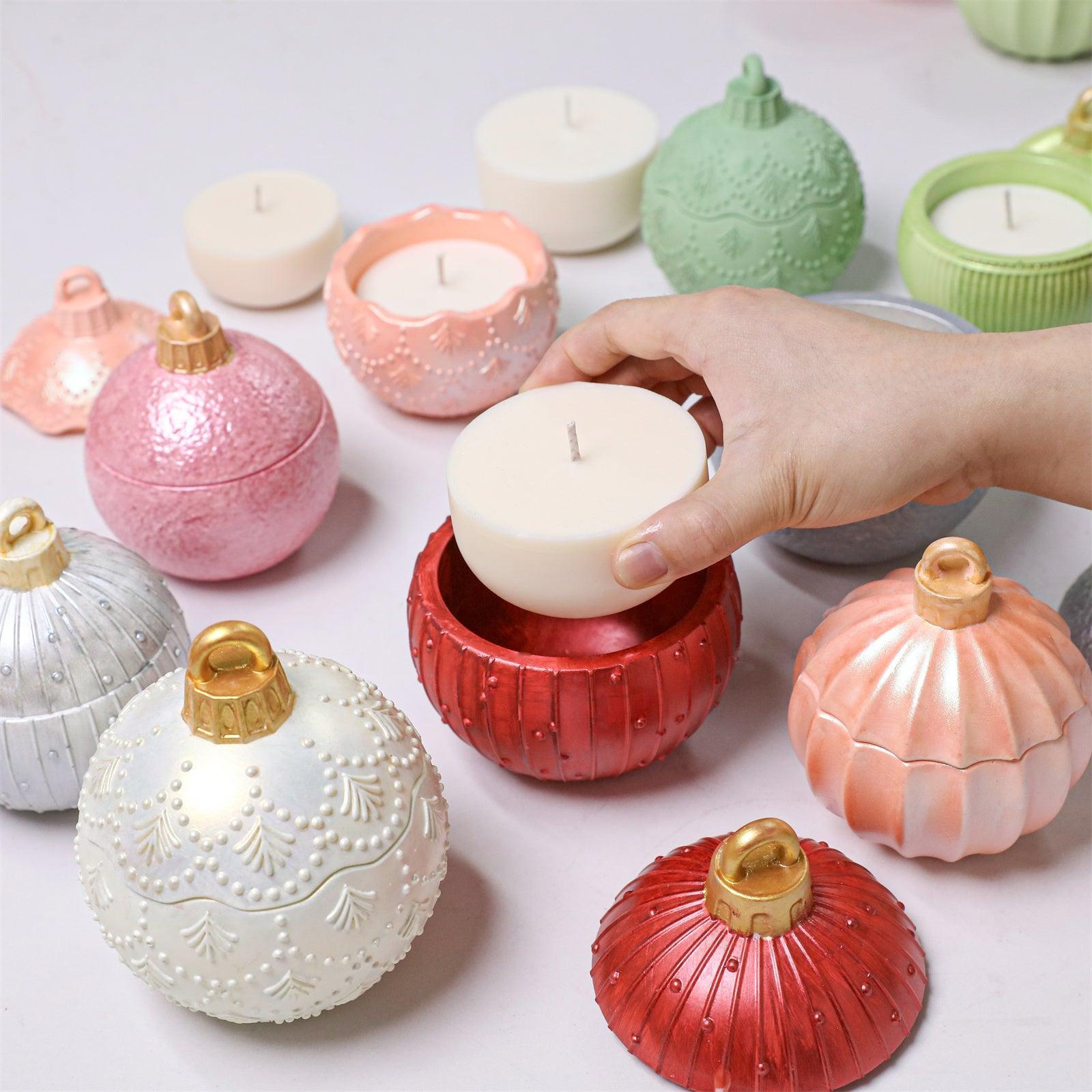 Hand placing a finished refill candle insert into a red Christmas bauble candle jar, surrounded by colorful decorative bauble containers Boowan Nicole