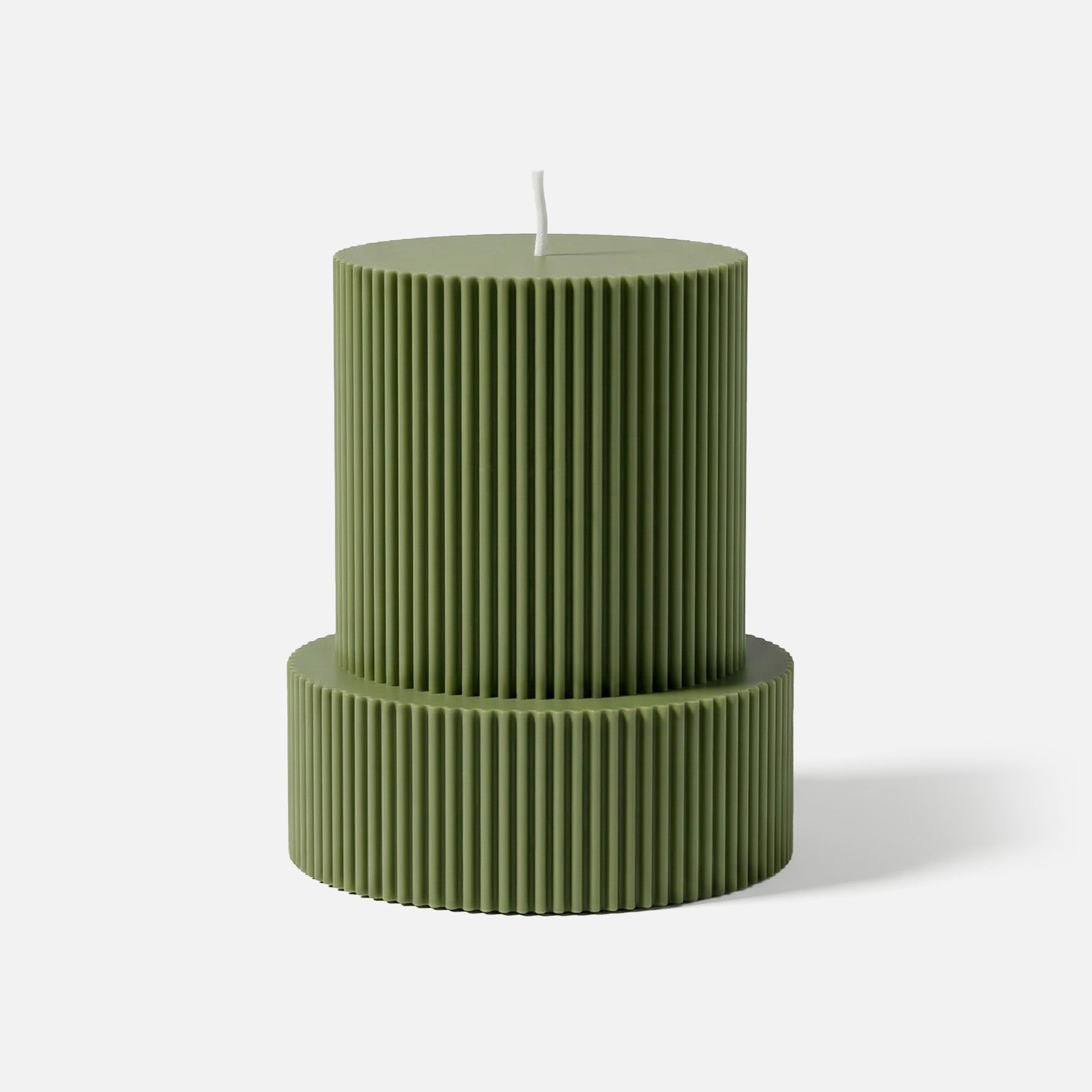 Two-tiered ribbed pillar candle in sage green, with vertical fluted texture, against a white background. -Boowan Nicole