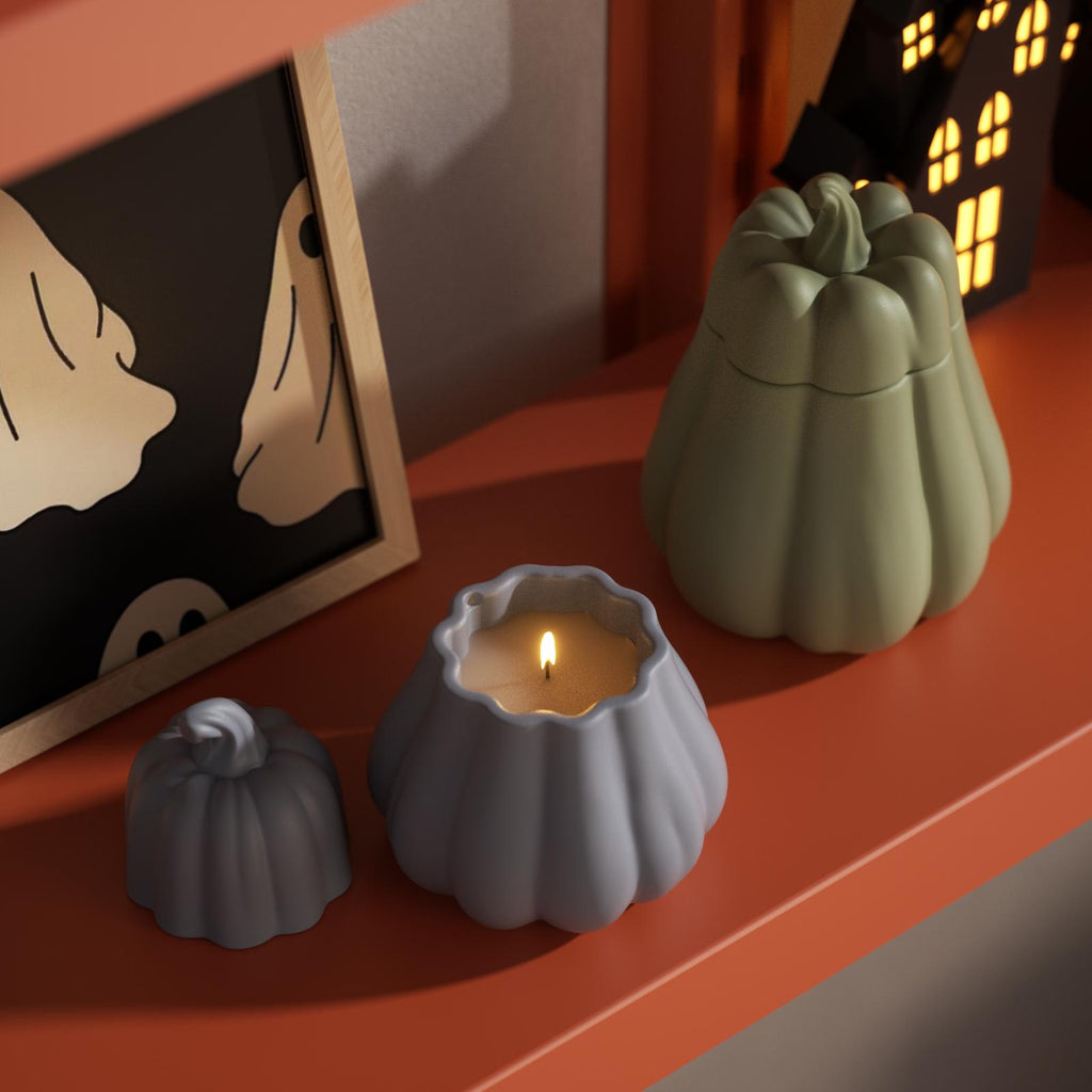 Blue and green pumpkin-shaped candle jars on an orange shelf, styled for Halloween home decor - Boowan Nicole