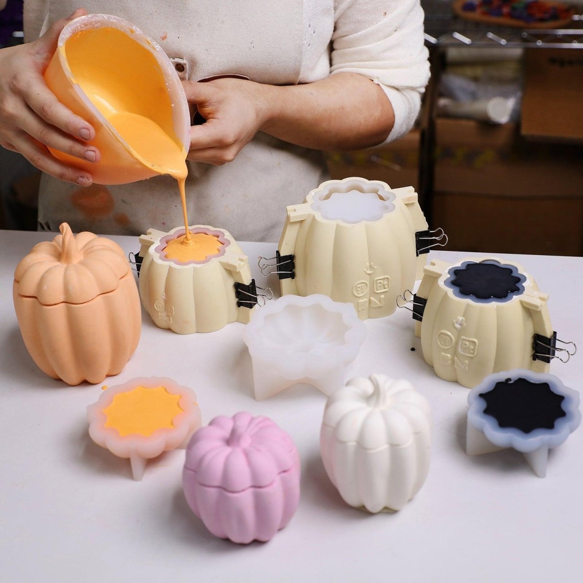 Pouring colored concrete into pumpkin molds with support shells for batch production - Boowan Nicole