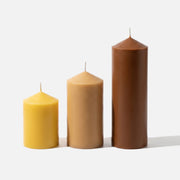 Classic Pointed Pillar Acrylic Candle Mold Collection, finished candles in warm yellow, beige, and brown tones, three sizes on white background - Boowan Nicole