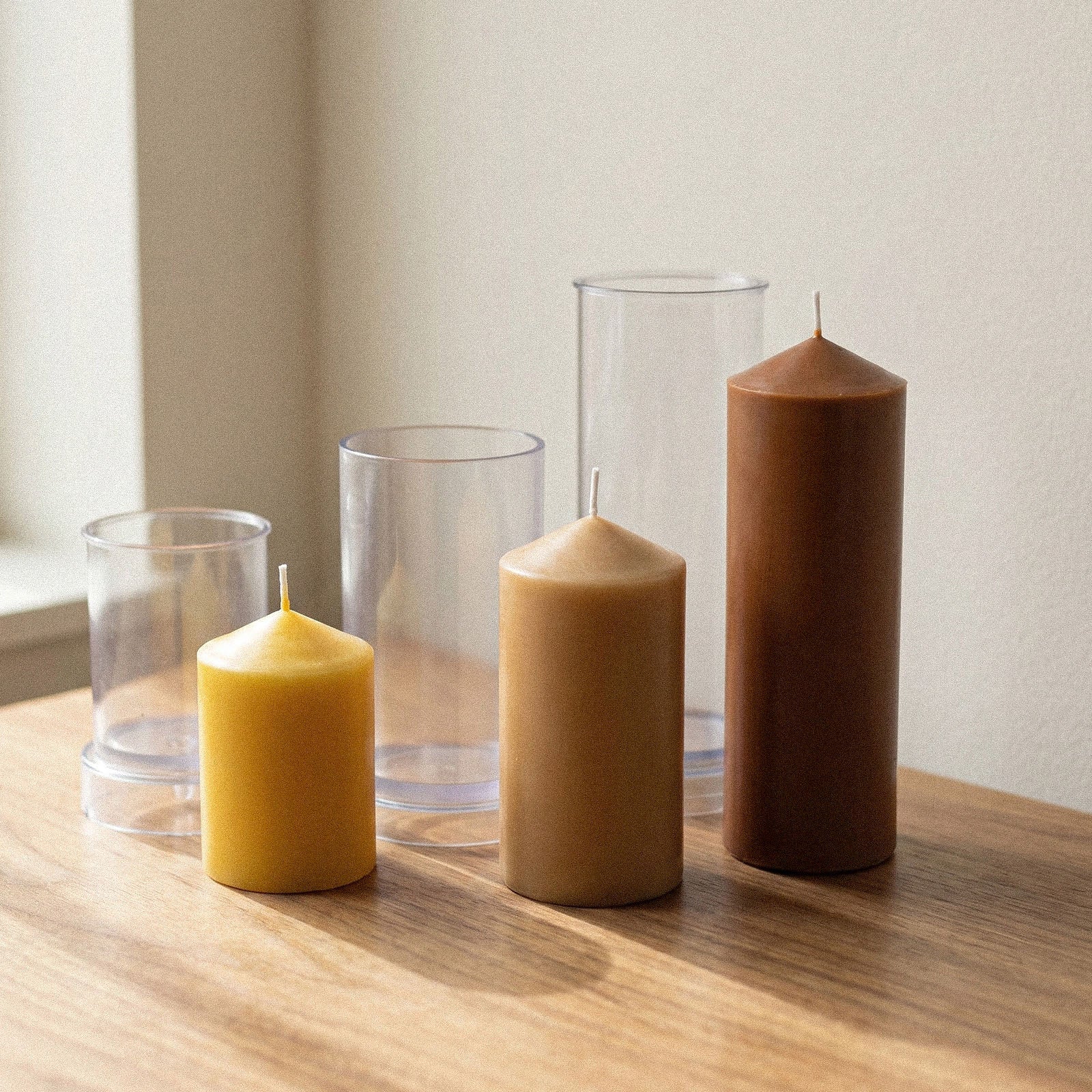 Classic Pointed Pillar Acrylic Candle Mold Collection, clear molds next to finished pillar candles in three sizes on wooden table - Boowan Nicole