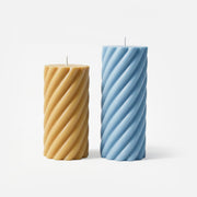 Twisted spiral pillar candle in warm amber, lit with melting wax - Boowan Nicole