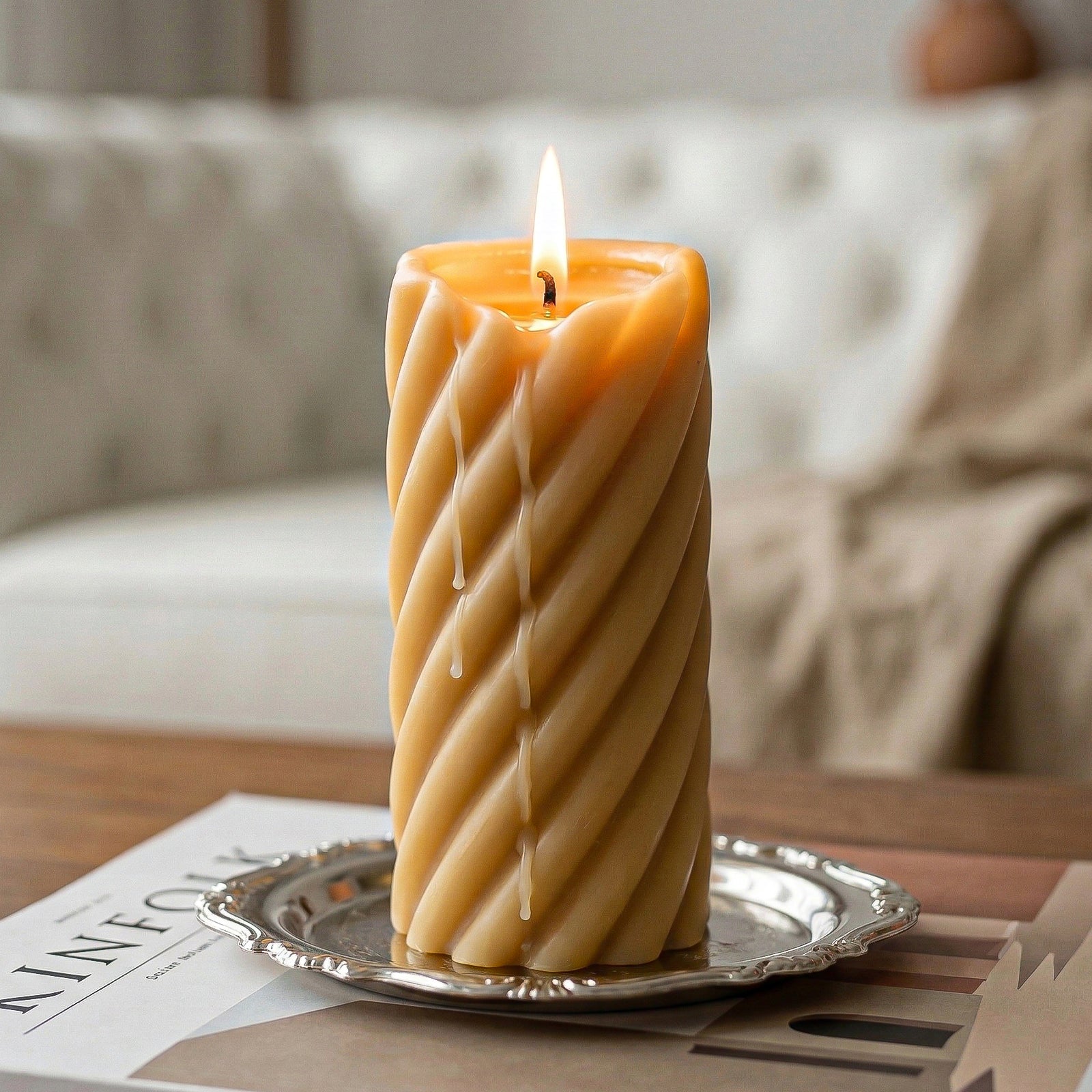 Close-up of lit twisted spiral pillar candle with warm glow - Boowan Nicole