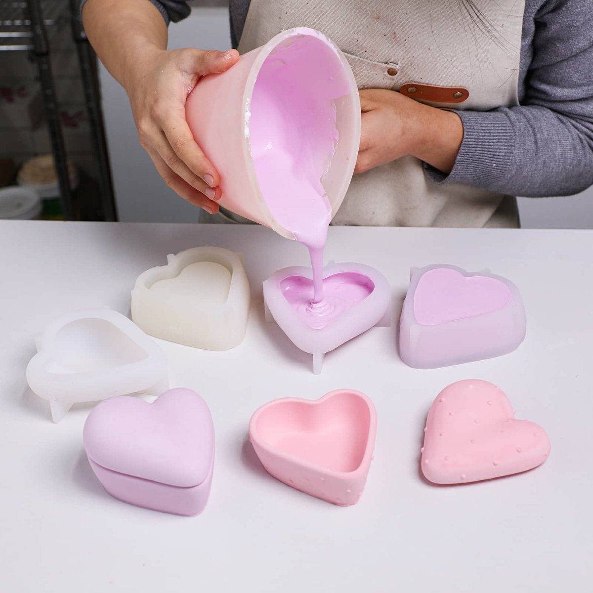 Pouring the prepared purple concrete mixture into a heart-shaped candle jar silicone mold - Boowan Nicole