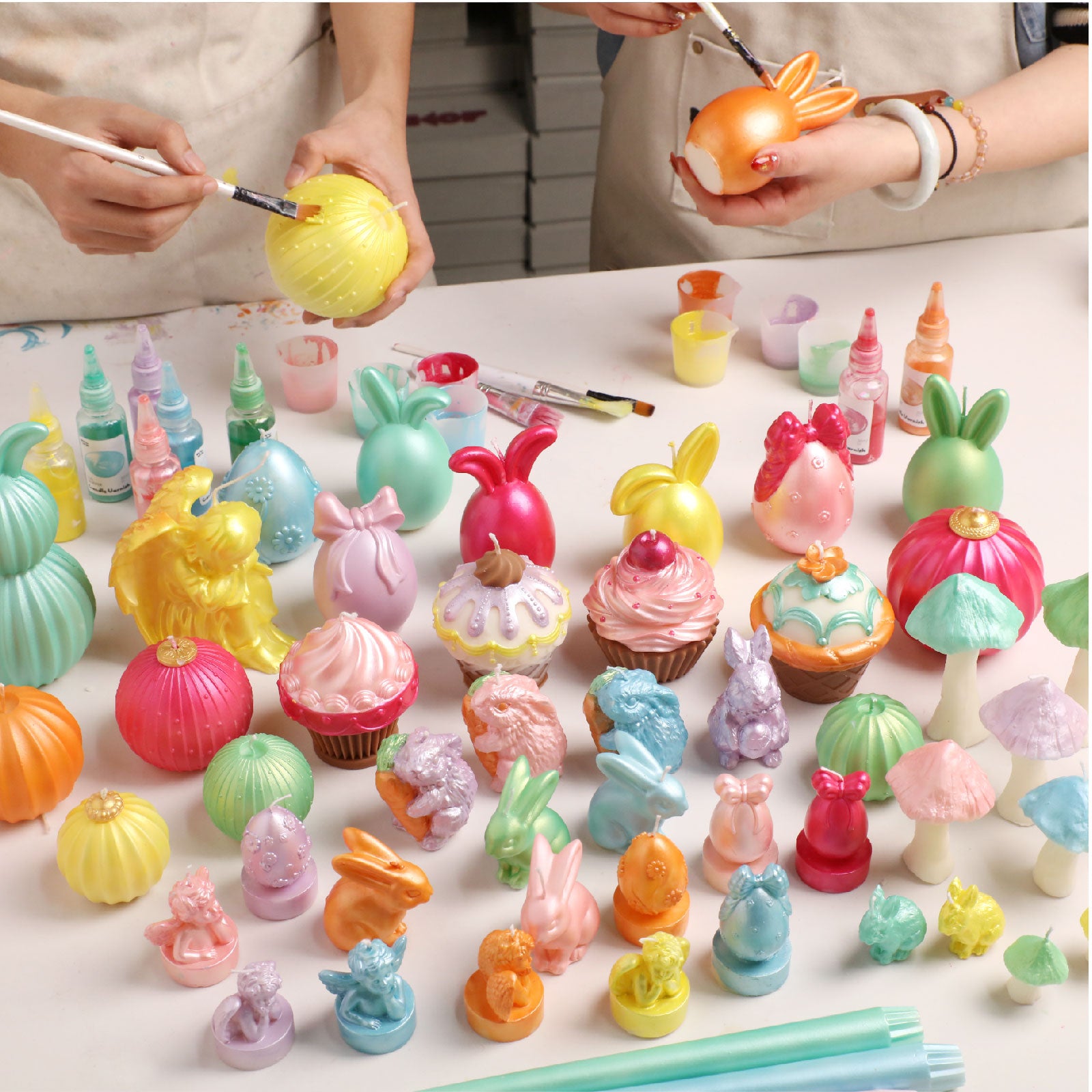 Artisans painting Easter-themed candle crafts with colored varnishes -Boowan Nicole