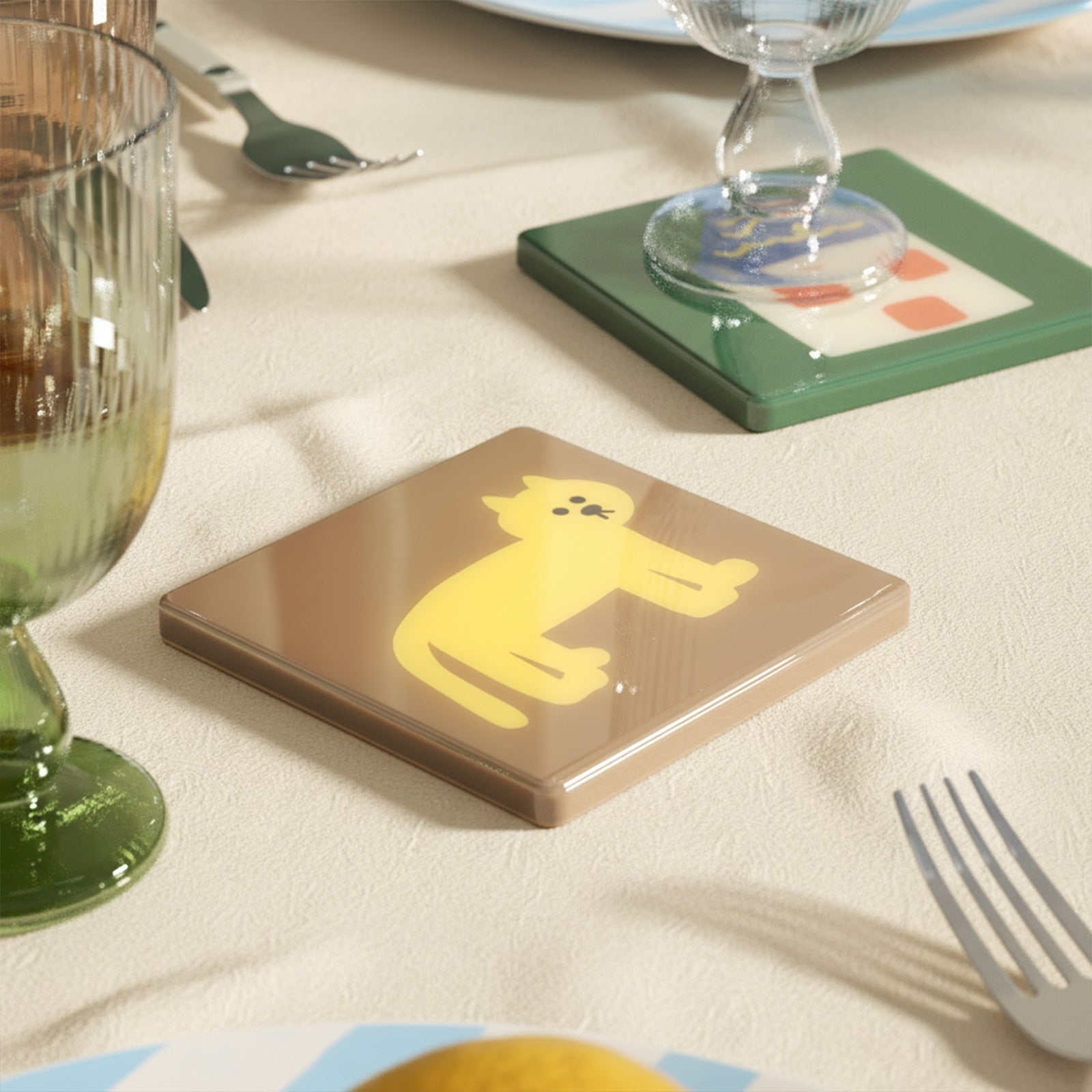 Glossy resin-coated cat coaster on a linen table with glassware and cutlery - Boowan Nicole