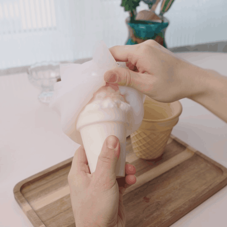 Demolding ice cream scoop candle, placing into waffle cone, and lighting the finished candle for product display - Boowan Nicole
