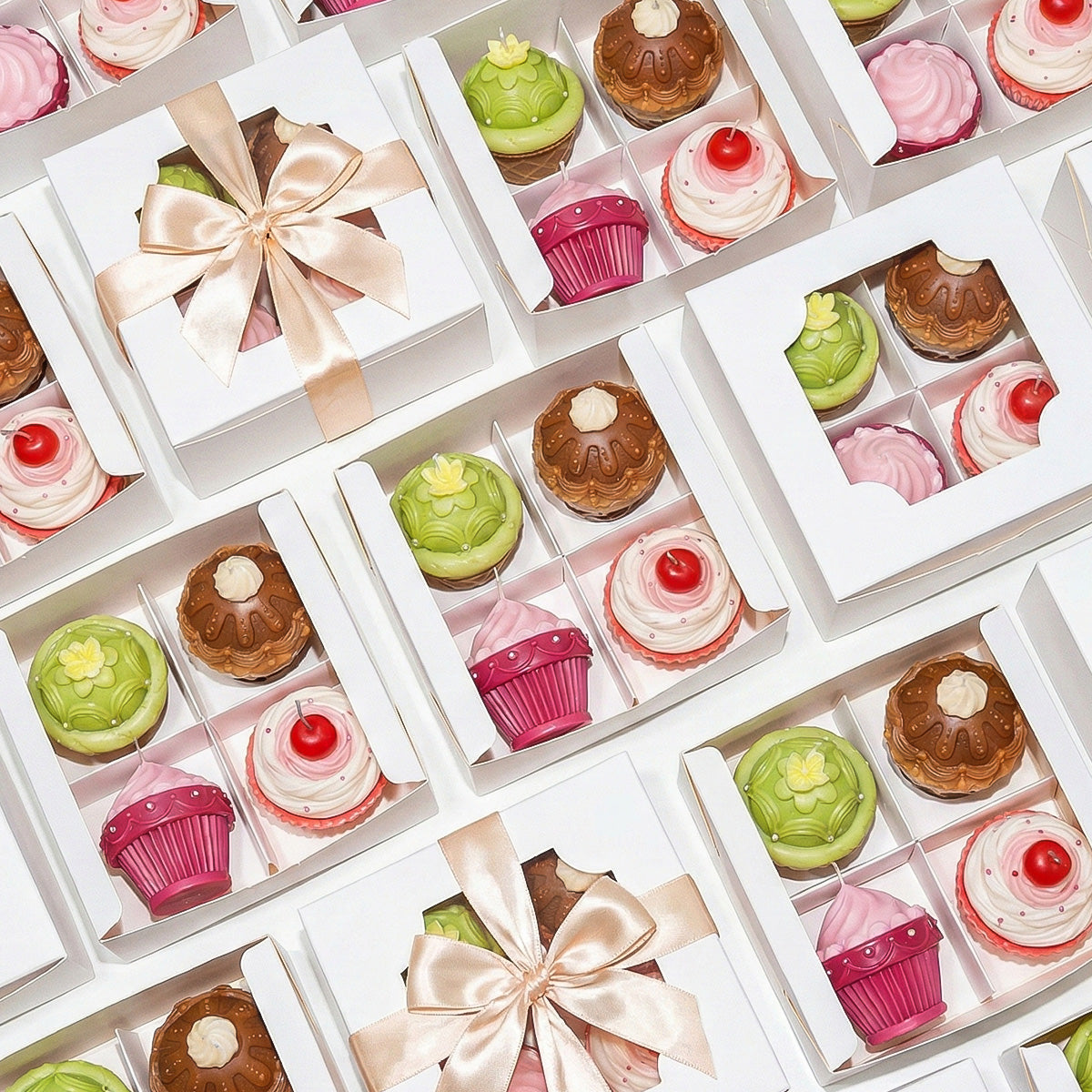 Flat lay of gift-boxed cupcake candles in white boxes with champagne ribbons, perfect for gifting - Boowan Nicole