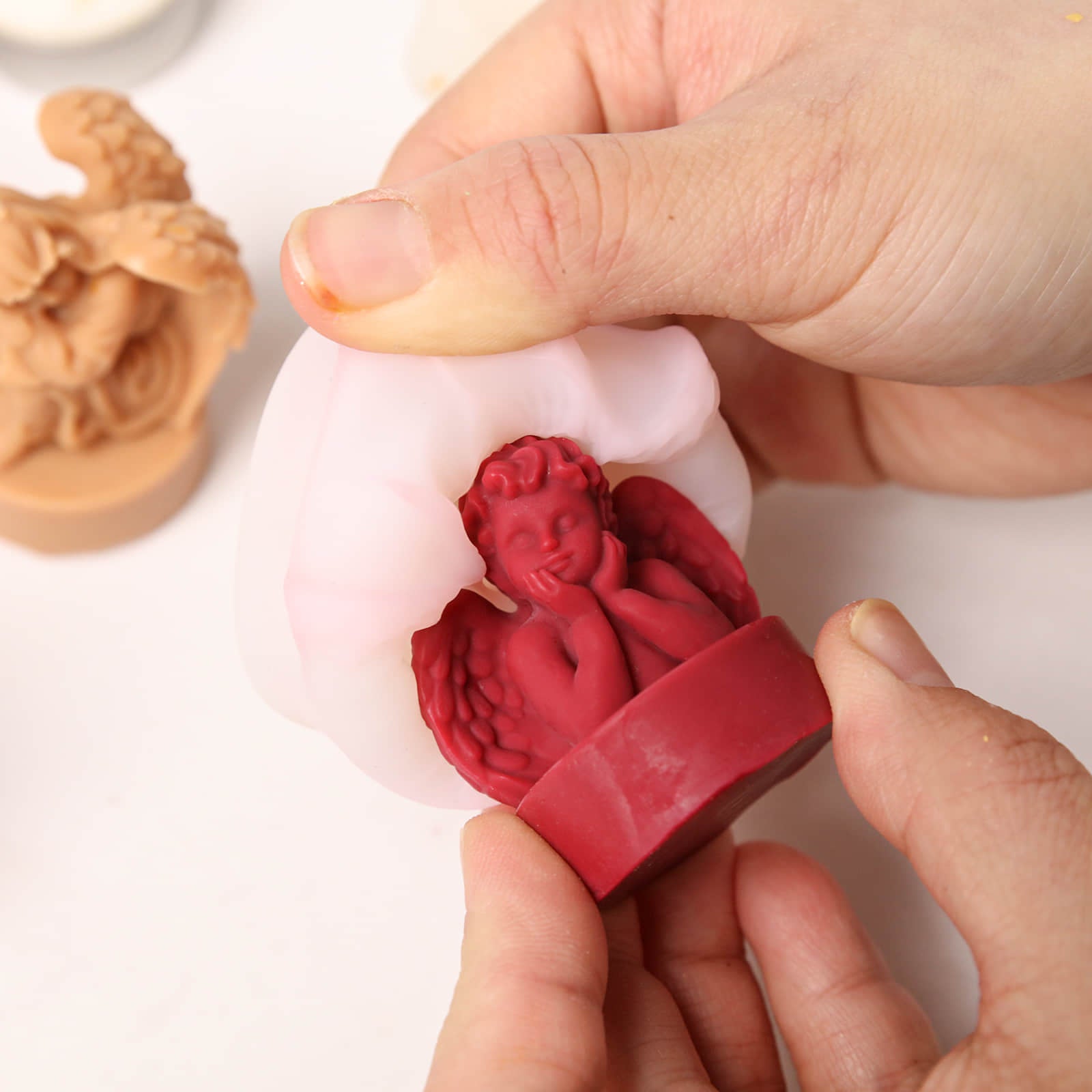 De-molding a red cherub angel candle from a white silicone mold - Boowan Nicole
