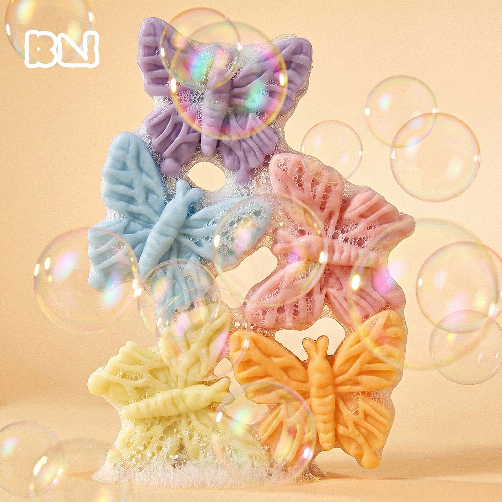 Colorful butterfly-shaped soaps with iridescent bubbles against a warm peach background - Boowan Nicole