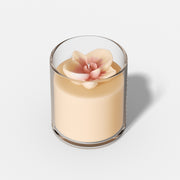 A glass jar candle with a 3D pink orchid topper, glowing softly when lit, showcasing delicate petal details. -Boowan Nicole