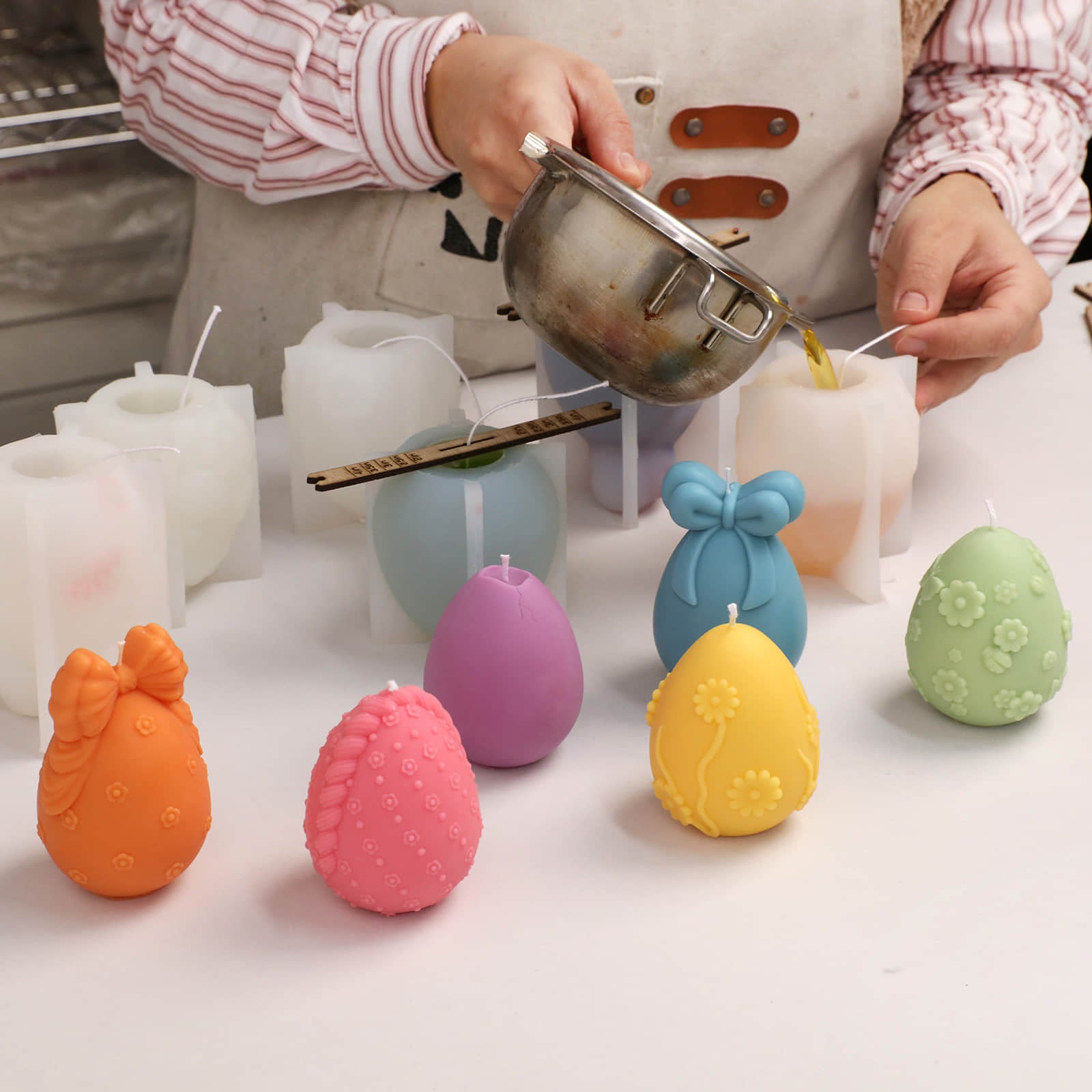 Handmade process of pouring wax into silicone molds to create decorative Easter egg candles - Boowan Nicole