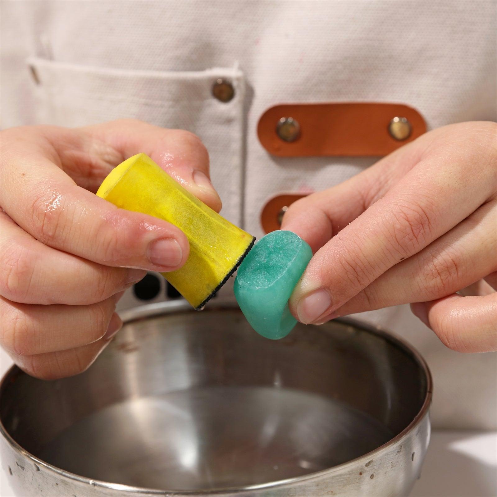 Sanding the bottom of the resin ring's pour spout with a grinder for a smoother and more refined finish-Boowan Nicole