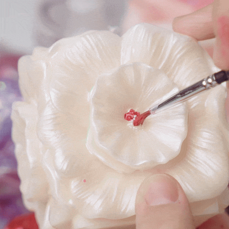 Close-up detail of painting a floral-shaped candle with glitter varnish - Boowan Nicole