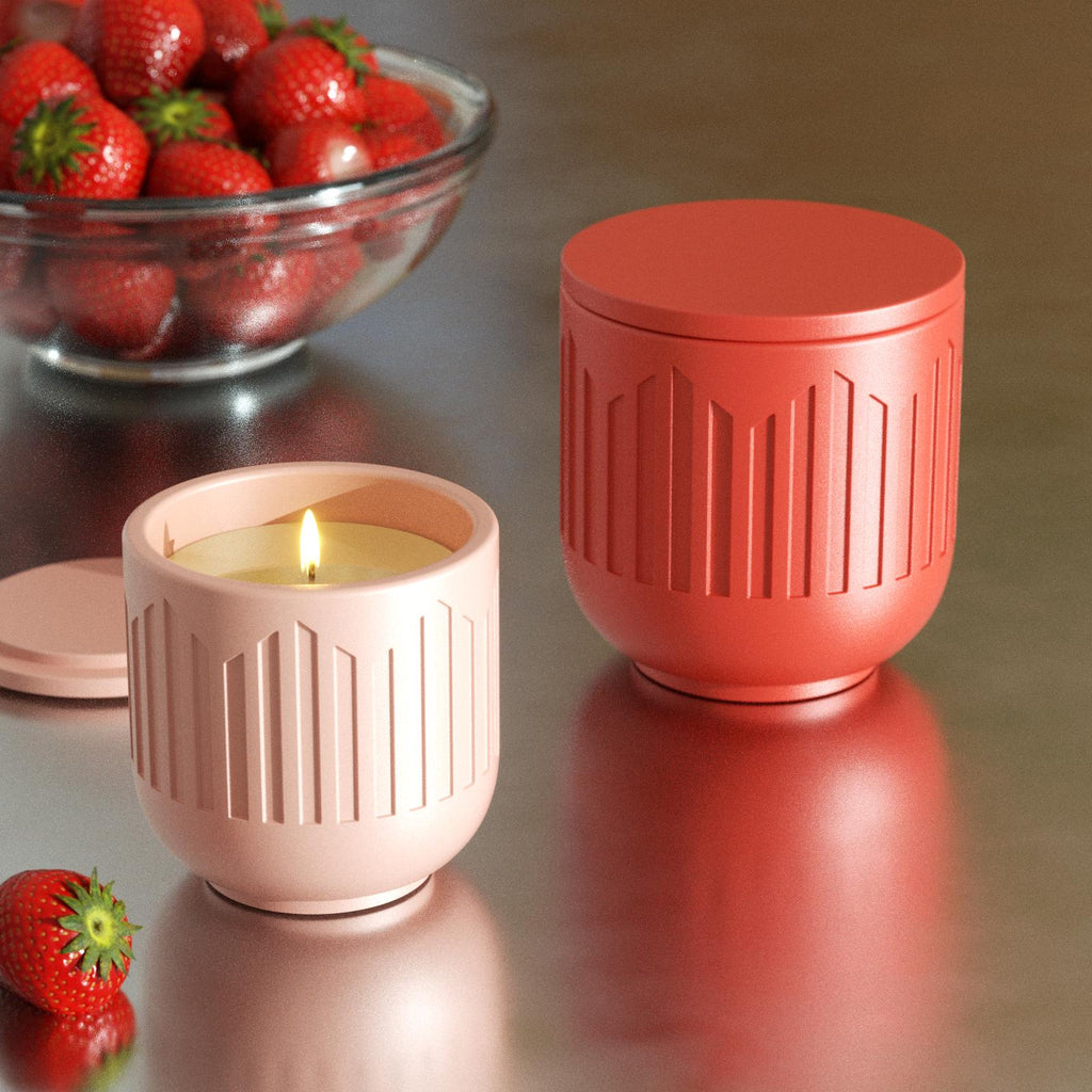 Lit pink candle jar and closed red jar on table with fresh strawberries - Boowan Nicole