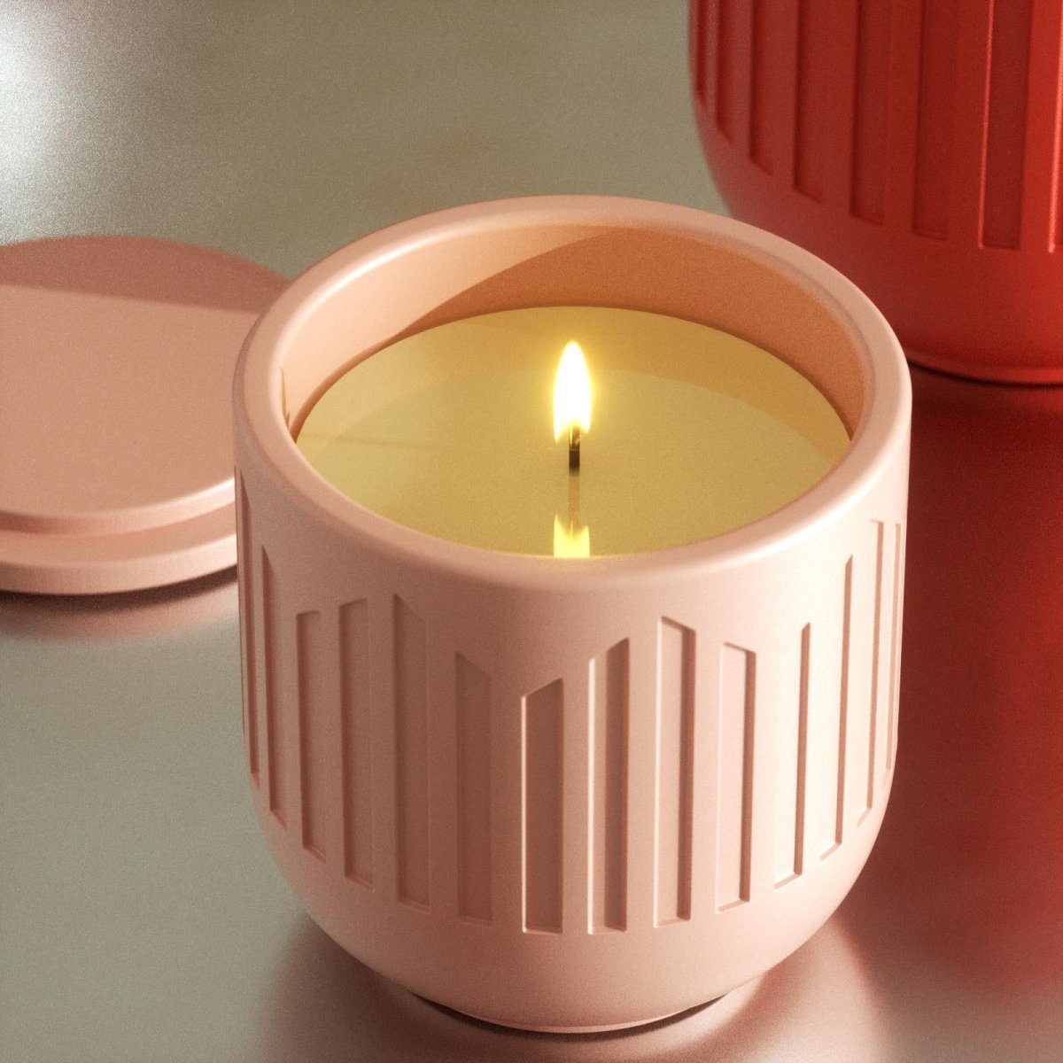 Lit candle in pink geometric jar with lid beside it on table - Boowan Nicole