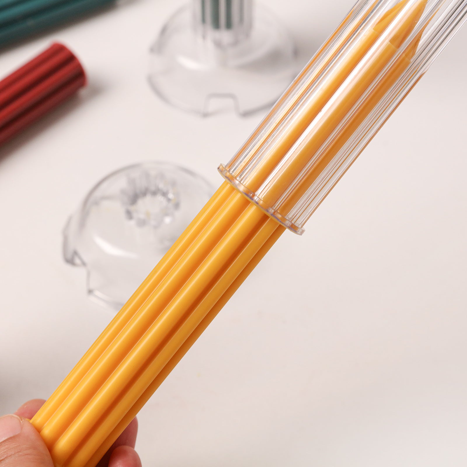 Detailed close-up of a yellow ribbed candle being inserted into a clear acrylic mold, showing the perfect fit and multi-channel design. -Boowan Nicole