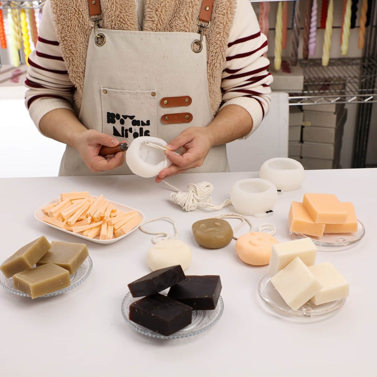 Soap making workspace with smiley face molds, soap bases, ropes, and handmade soap supplies. - Boowan Nicole
