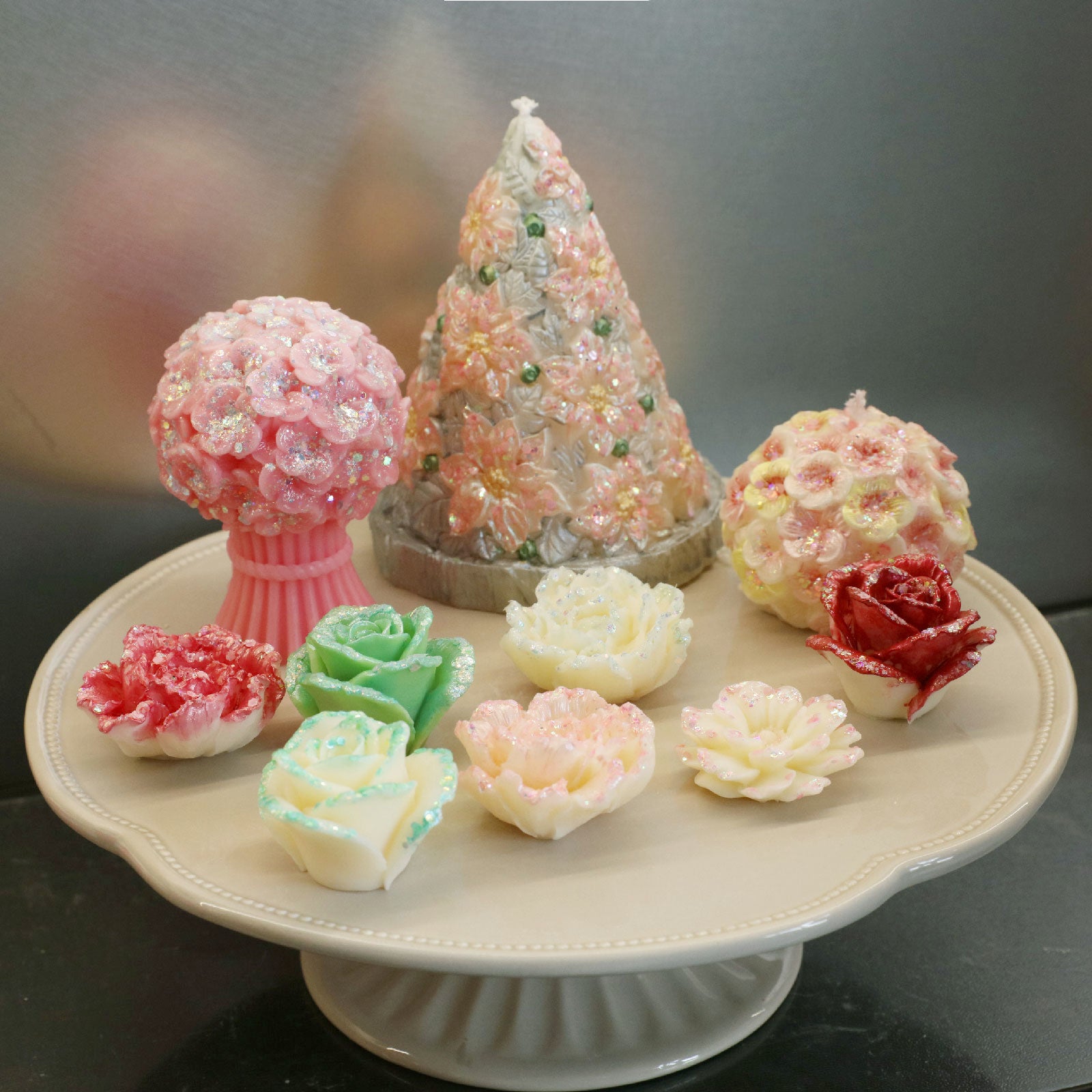 Shimmering floral handmade candles collection with glitter finish on a display pedestal - Boowan Nicole