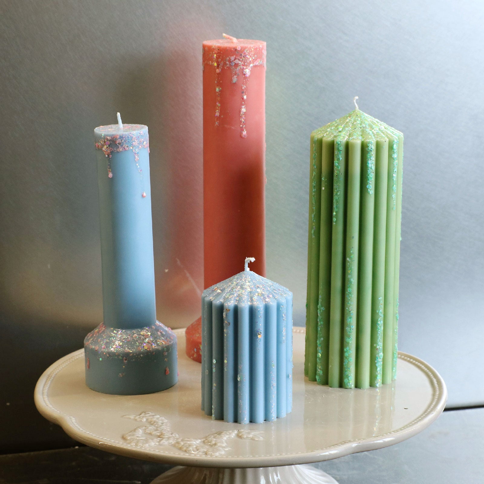Decorative blue, green, and peach glitter-drip pillar candles for DIY home decor inspiration - Boowan Nicole