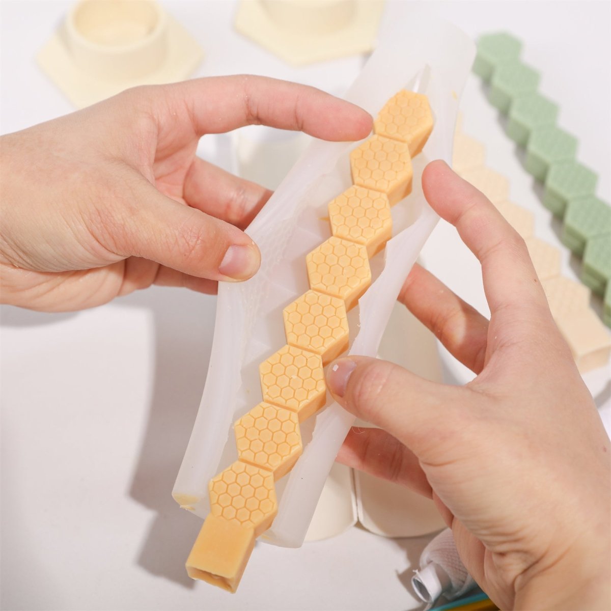 Demold the honeycomb-patterned taper candle made from beeswax.