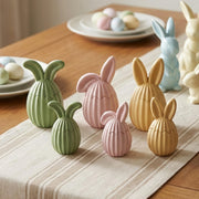 Pastel ribbed bunny egg candle jars in green, pink, and yellow on an Easter table runner - Boowan Nicole