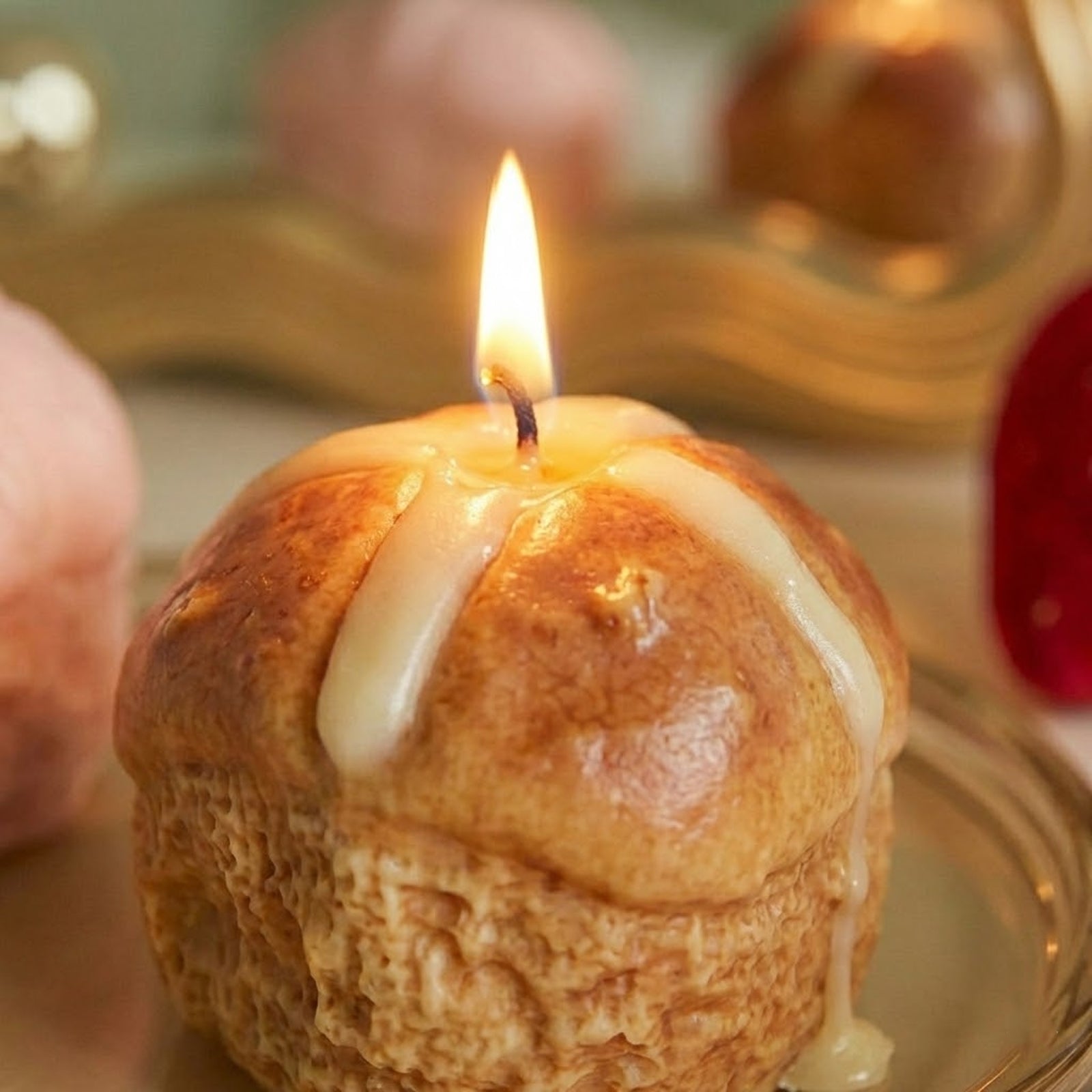 Close-up of Lit Hot Cross Bun Scented Candle with Melting Icing - Boowan Nicole