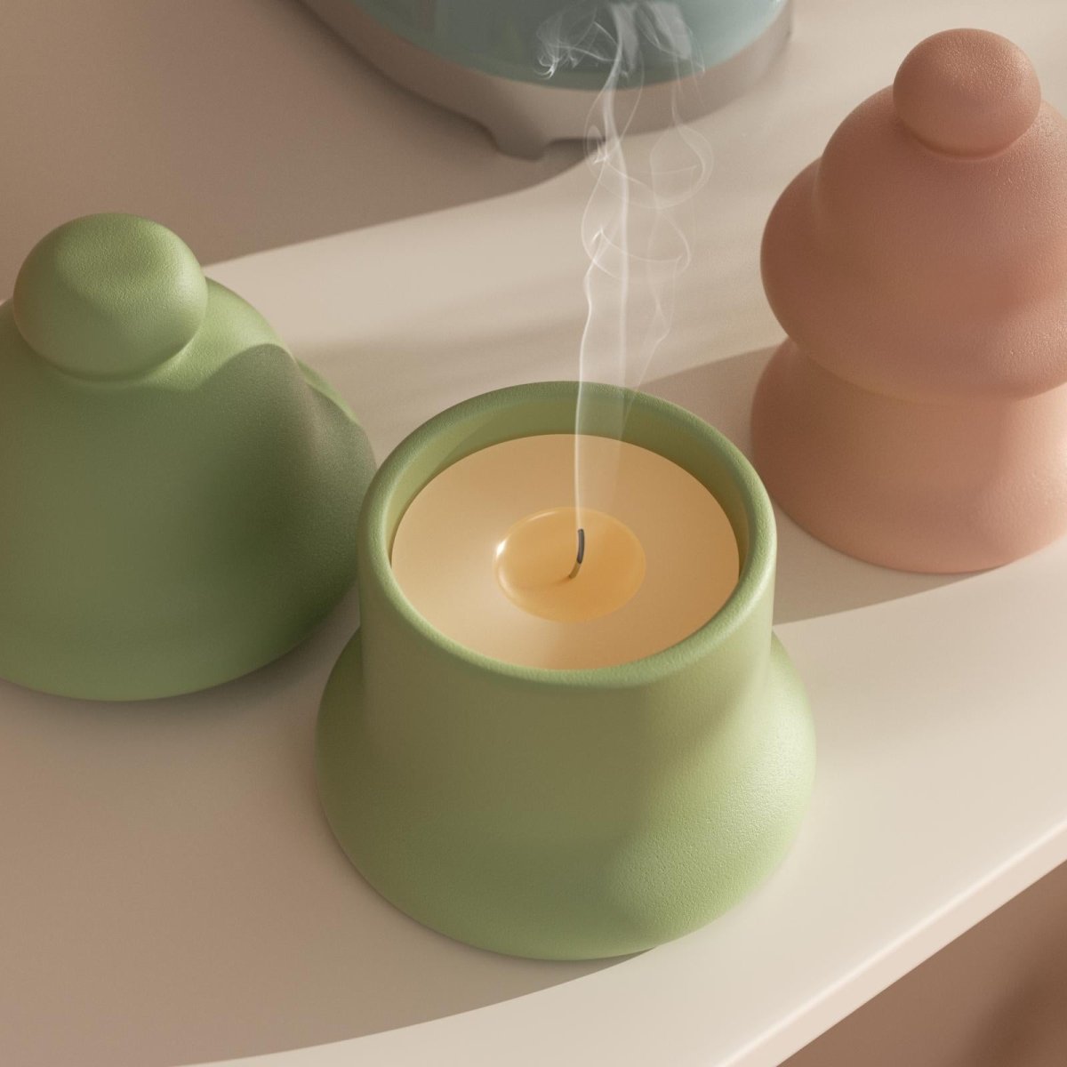 Green handmade candle jar with smoke and matching lid on tabletop - Boowan Nicole