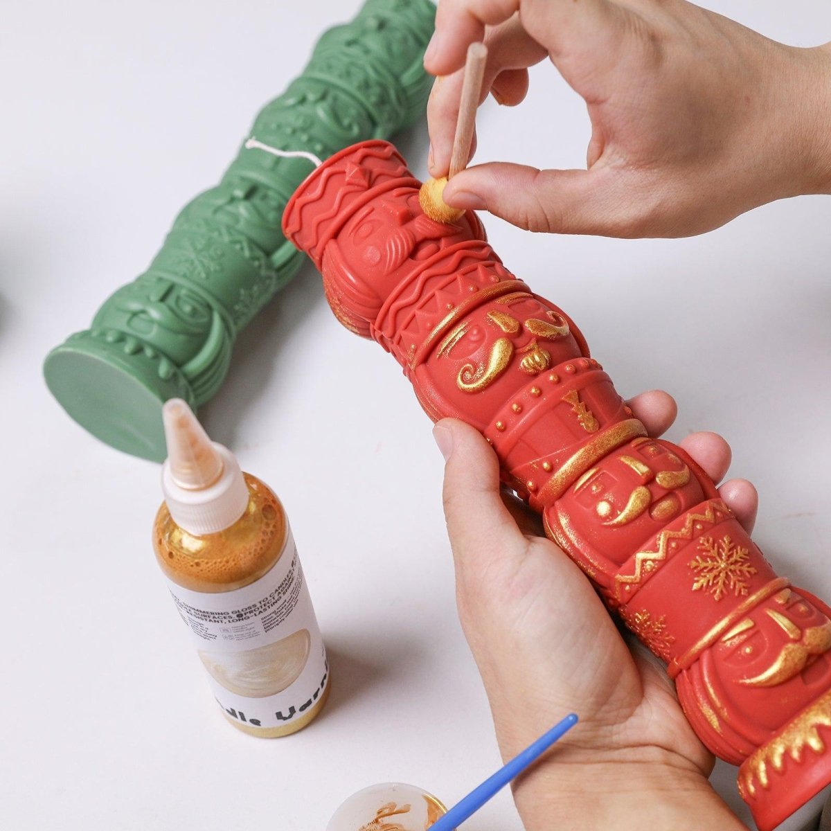 Hand-painting a red nutcracker totem candle with gold varnish – DIY Christmas decoration using sponge tool and detailing brush - Boowan Nicole