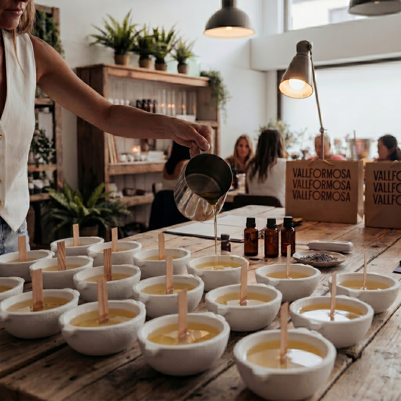 Workshop Scene of Pouring Wax into Multiple Blank Lemon Boat Candle Containers - Boowan Nicole