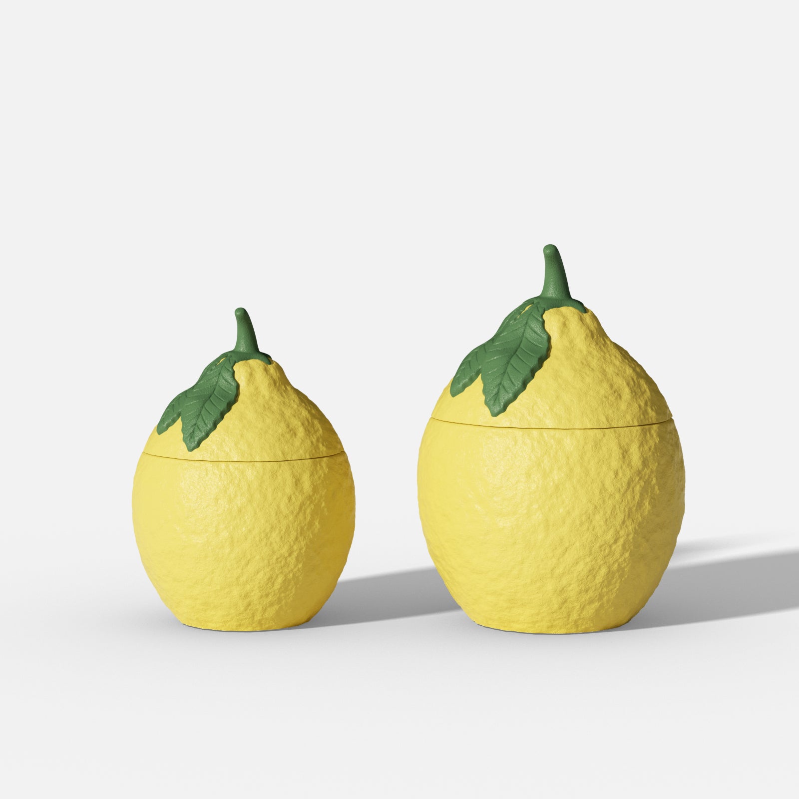 Two lemon-shaped lidded jars with green leaf tops and textured peel on a white background - Boowan Nicole