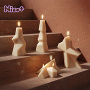 Abstract geometric pillar candles in warm ivory wax displayed on terracotta steps, showing the sculptural shapes made with our silicone molds - Boowan Nicole