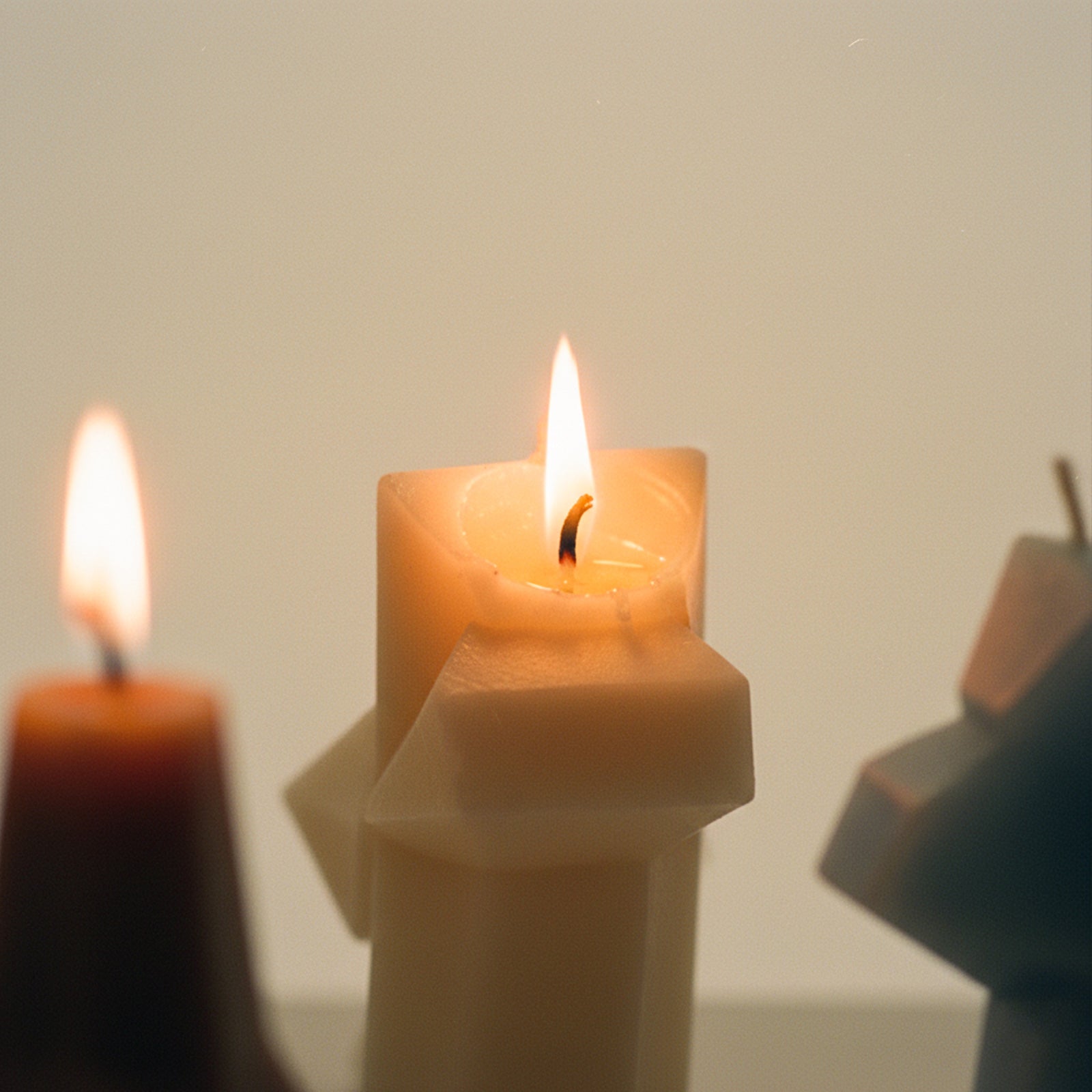 Close-up of an abstract geometric pillar candle burning - Boowan Nicole