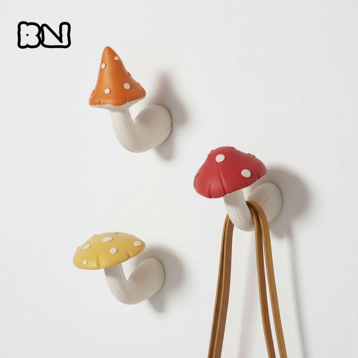 Three mushroom-shaped wall coat hooks in orange, red, and yellow with white dots, cast from the Mushroom Buddies silicone mold - Boowan Nicole