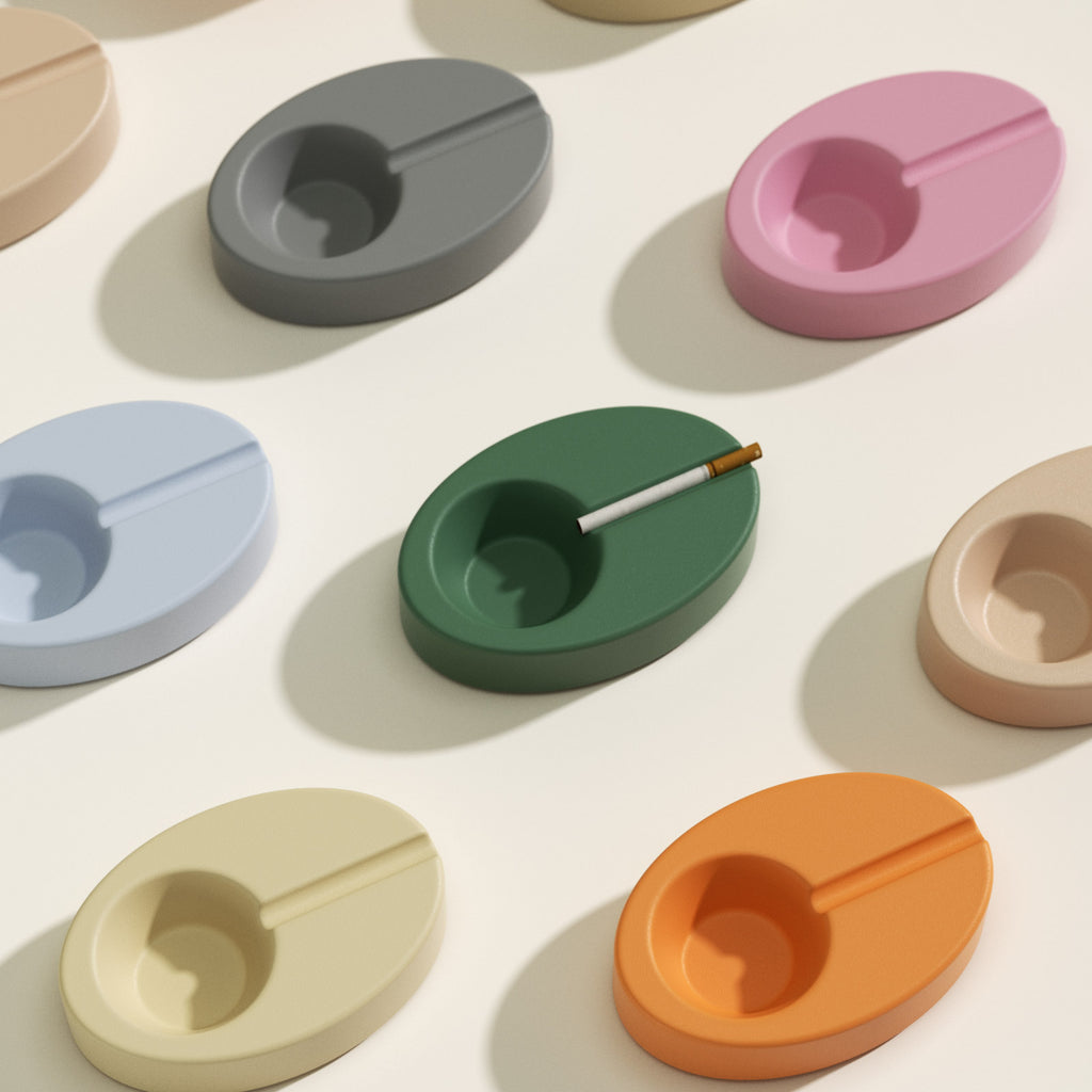Assorted color Orbit oval ashtrays with bowl and slim groove; one green piece holding a cigarette—cast using the Orbit Ashtray Silicone Mold - Boowan Nicole