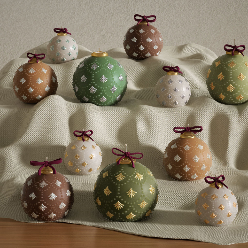 Assorted Christmas bauble candles with fir embossing and ribbon bows—green, cocoa, and ivory—various sizes styled on draped fabric - Boowan Nicole