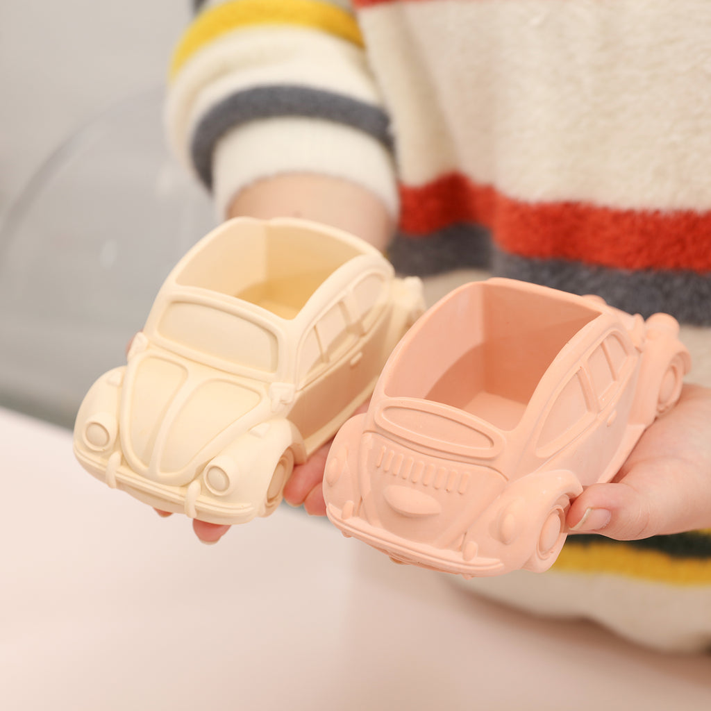 Handheld display of yellow and pink car-shaped plant pots made using a silicone mold set.
