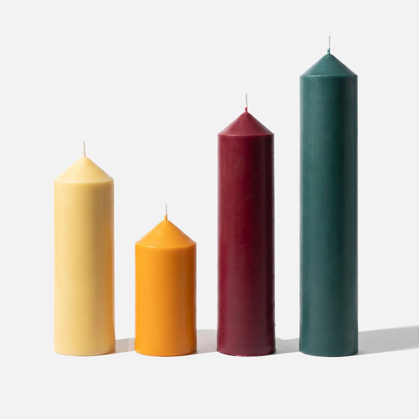 Pointed Pillar Candles in Four Colors on Plain White Background - Finished Product Display - Boowan Nicole