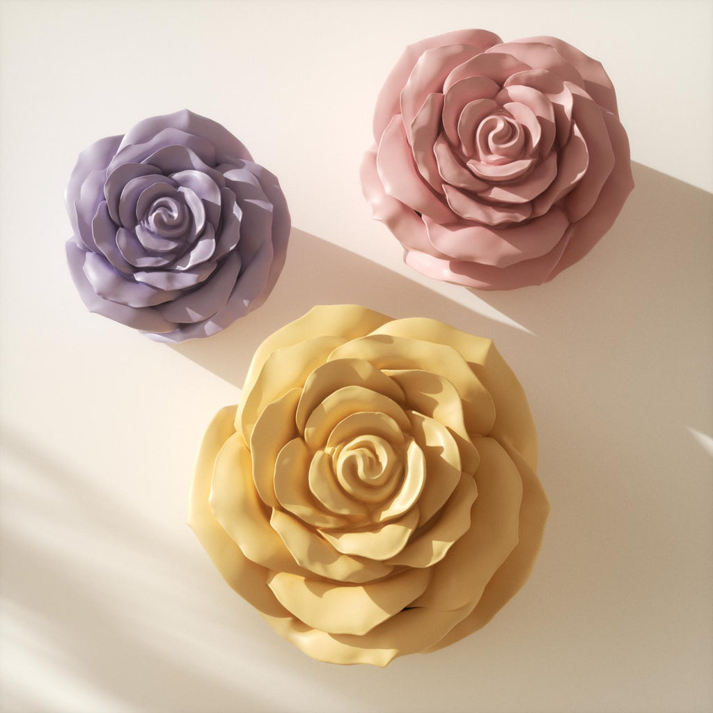 Top view of three rose-shaped candle jars in pastel purple, pink, and yellow colors arranged on a light background with soft shadows - Boowan Nicole