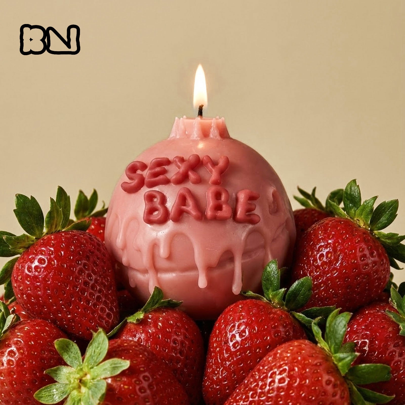 Lit pink "SEXY BABE" round candle with dripping wax effect surrounded by strawberries - Boowan Nicole