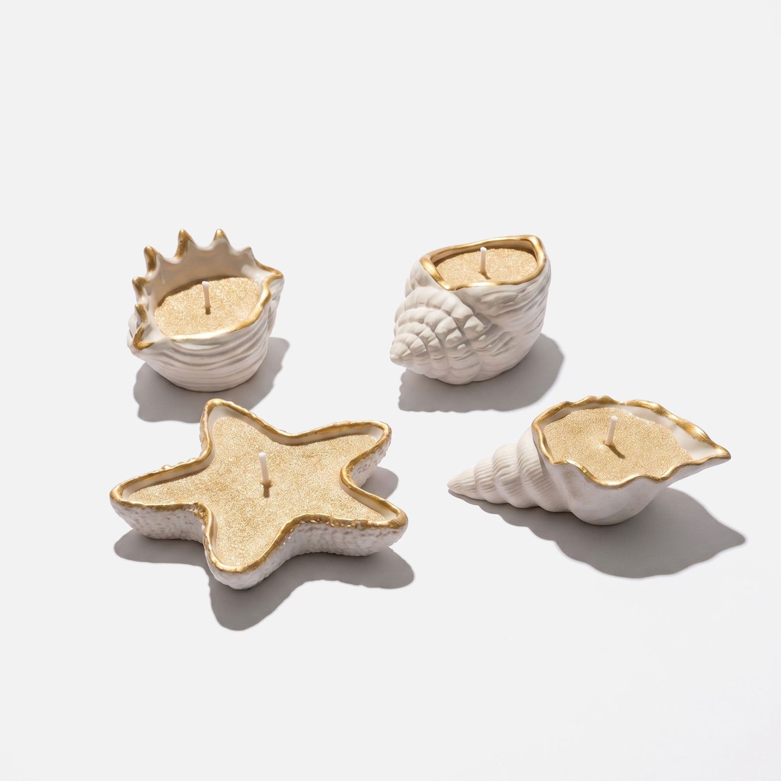 Four Styles White Ceramic Gold Trim Starfish & Conch Shaped Sand Wax Candles on Plain White Background - Boowan Nicole