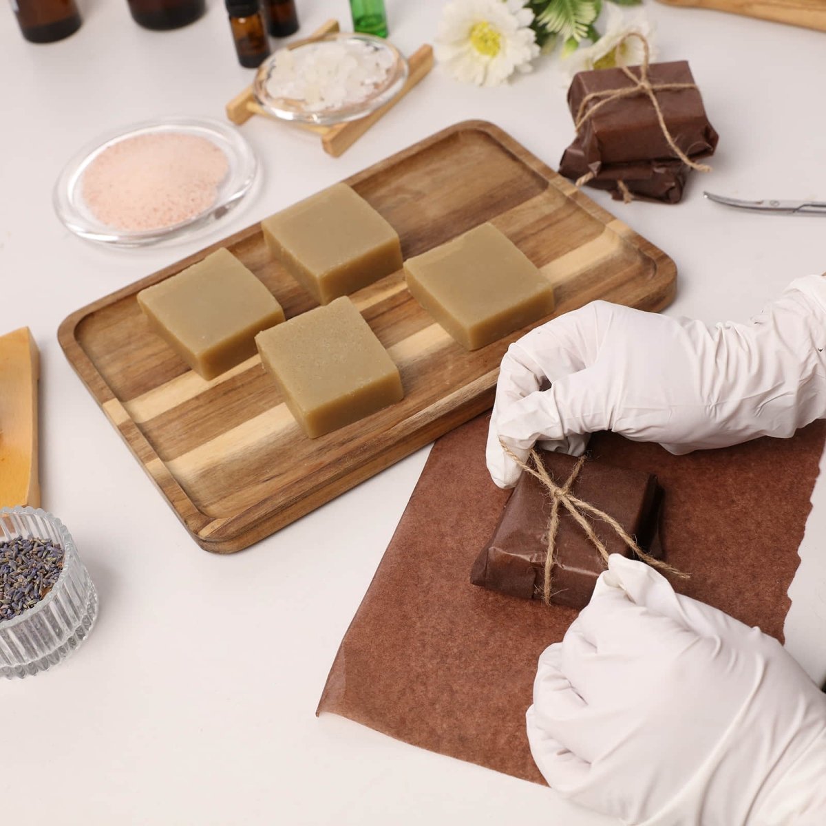 Artisanal packaging of Herbal Sea Salt Soap showing gloved hands hand-wrapping handmade soap bars - Boowan Nicole