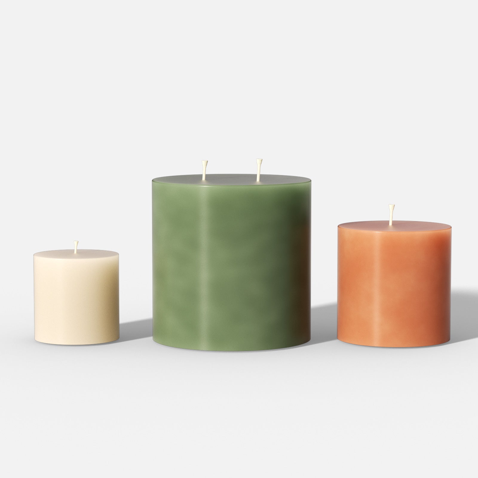 Set of smooth cylinder pillar candles—small ivory (single wick), large green (double wick), and medium terracotta—on a white background - Boowan Nicole