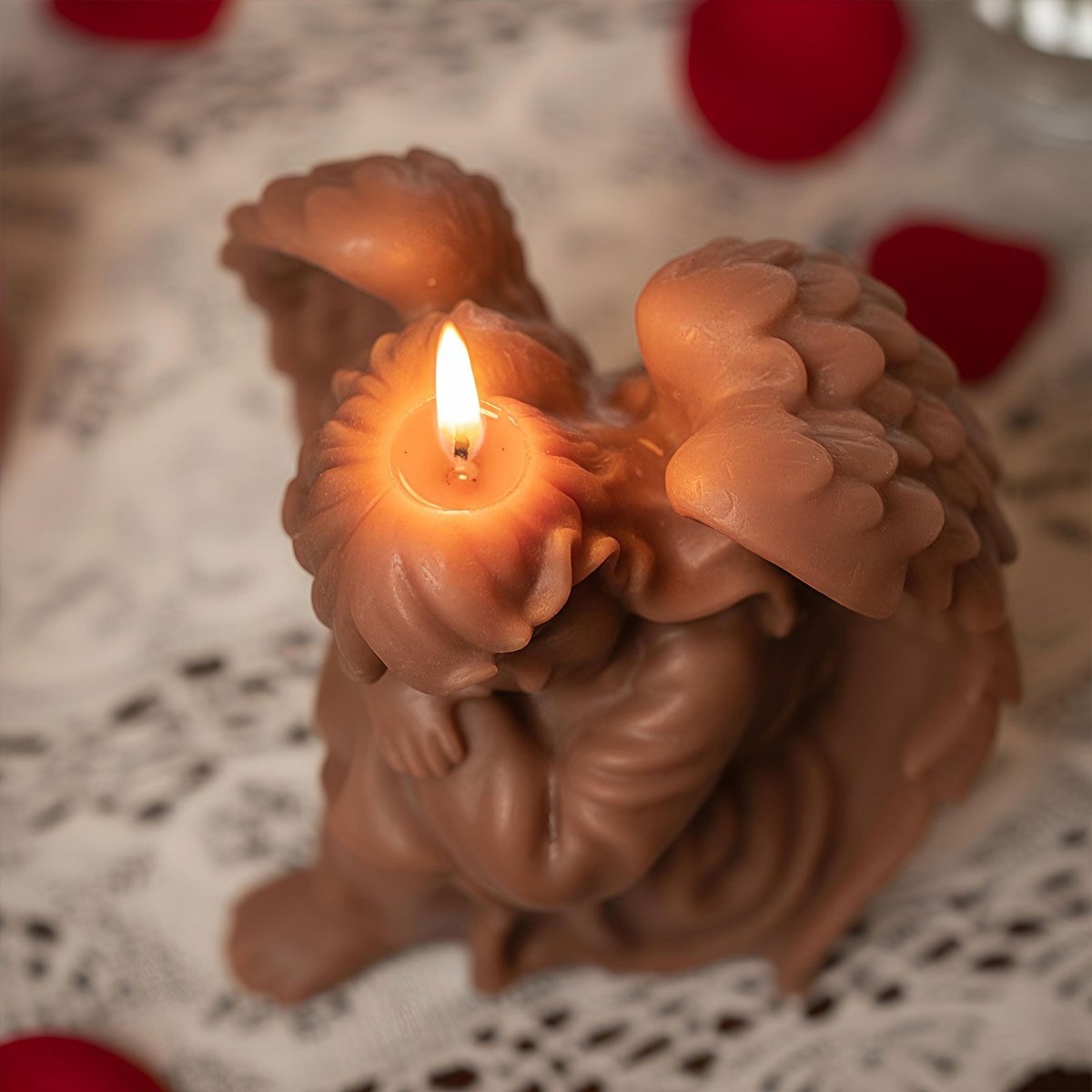 Cocoa-brown sleeping angel candle burning—wing and hair swirls visible on lace - Boowan Nicole