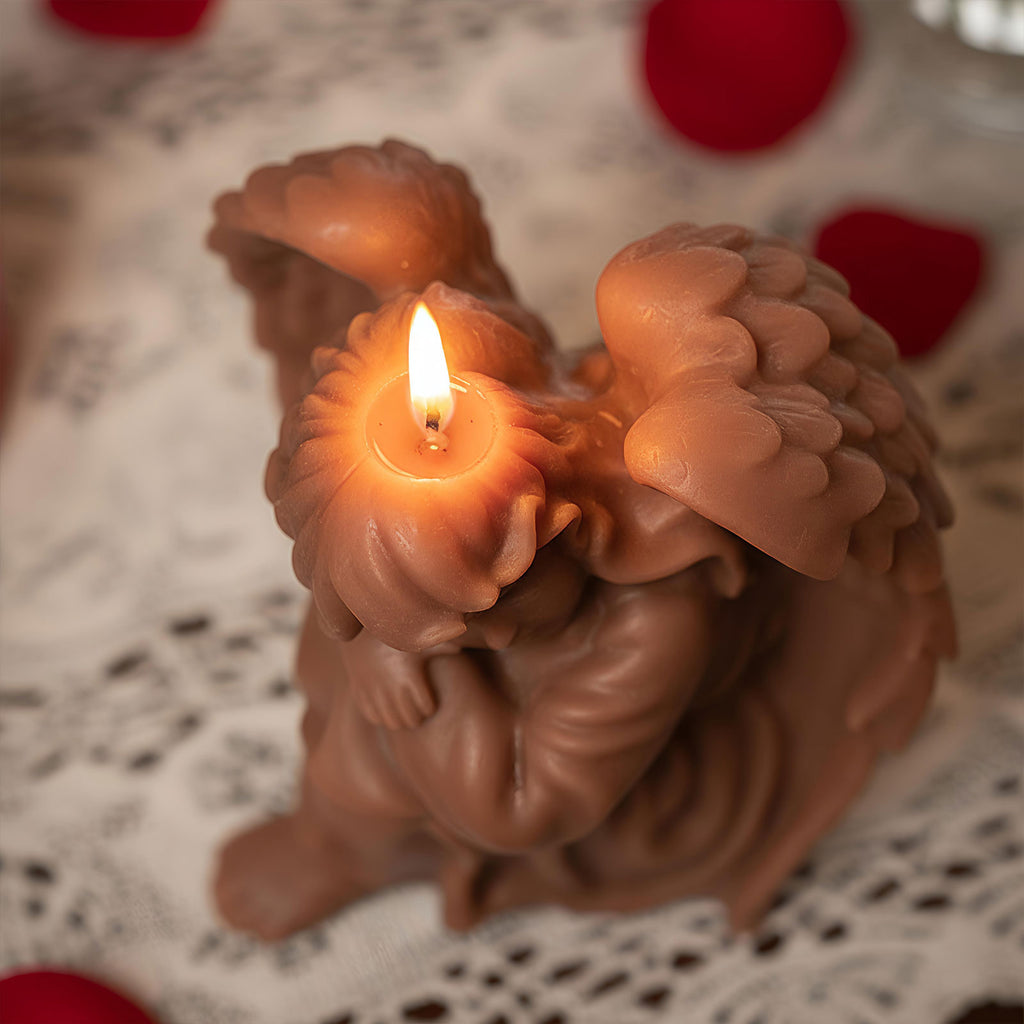 Cocoa-brown sleeping angel candle burning—wing and hair swirls visible on lace - Boowan Nicole