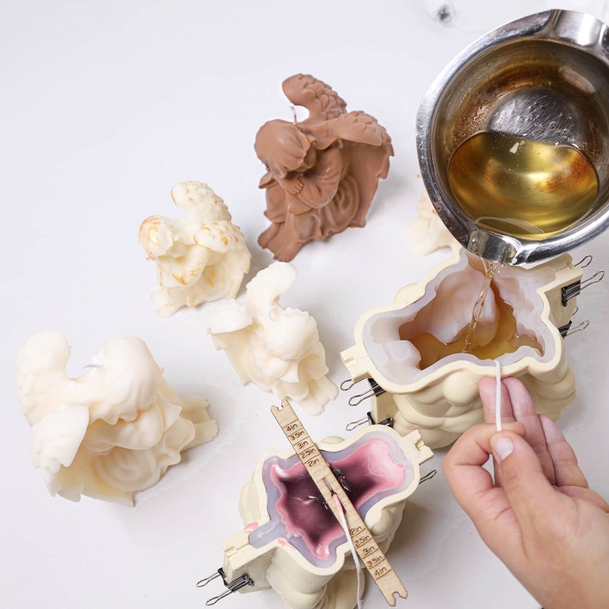 Pouring the prepared wax into the angel candle silicone mold with a support shell - Boowan Nicole