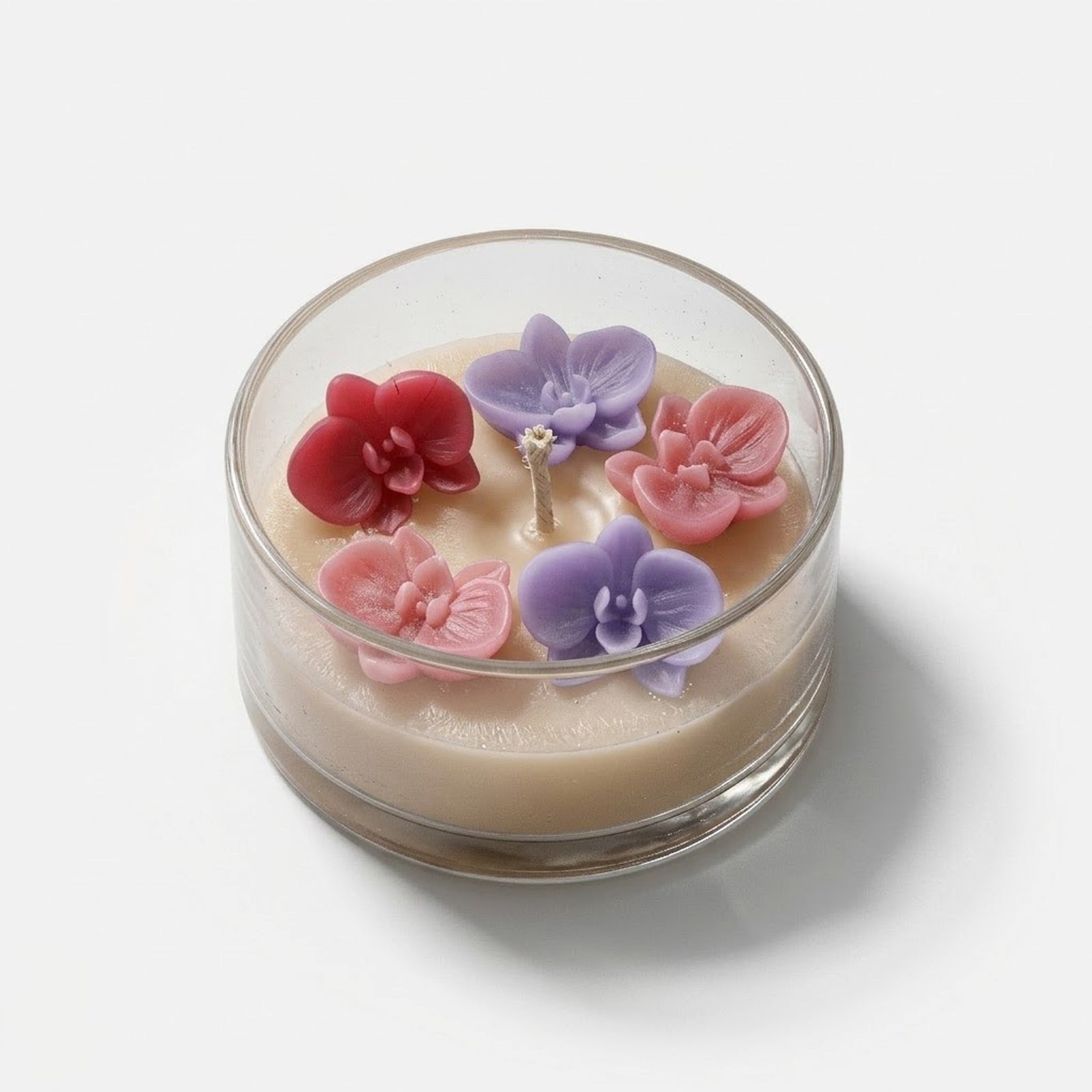 A glass jar candle with five 3D orchid toppers in red, pink, and purple, showcasing a delicate floral arrangement. -Boowan Nicole